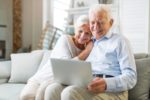 Ældre par bruger en bærbarcomputer derhjemme